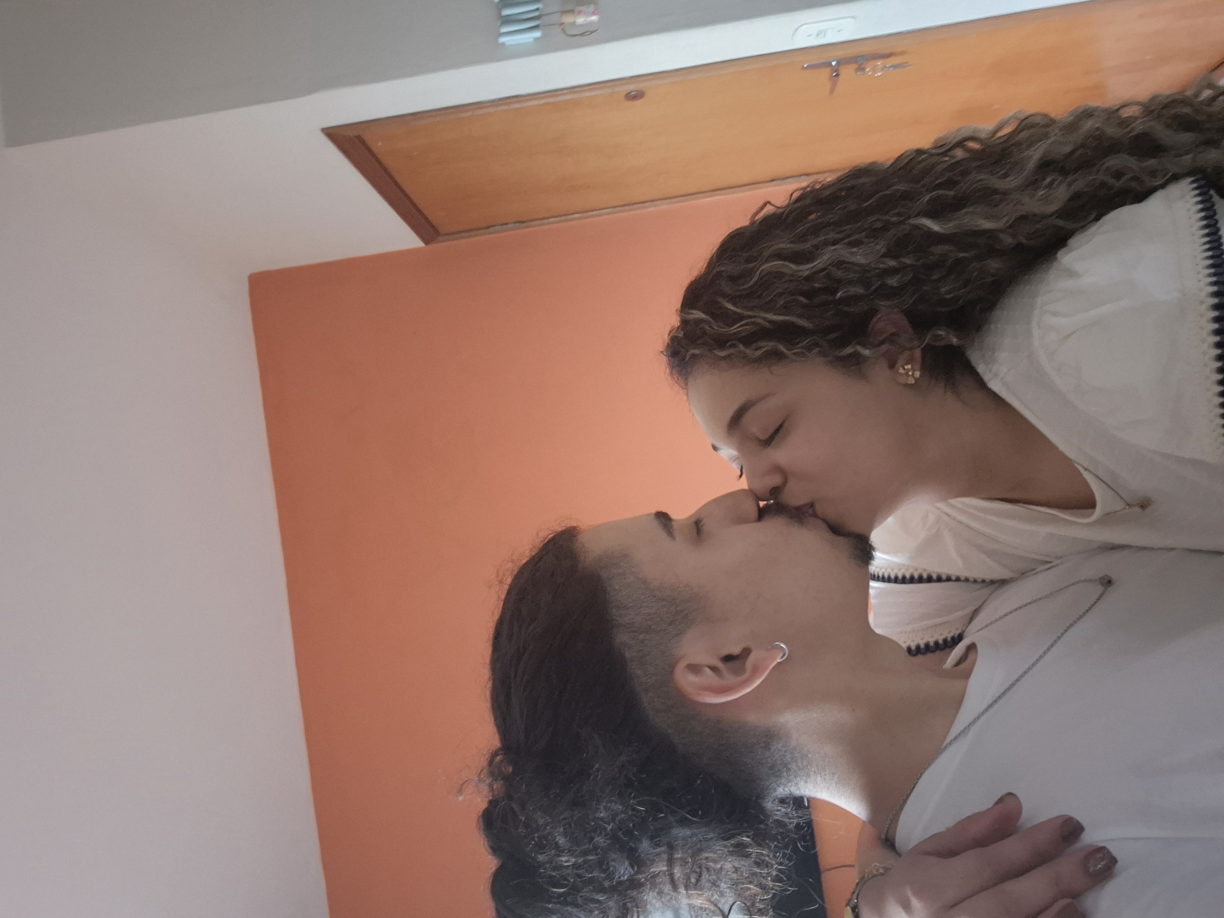 O casal se beijando em casa