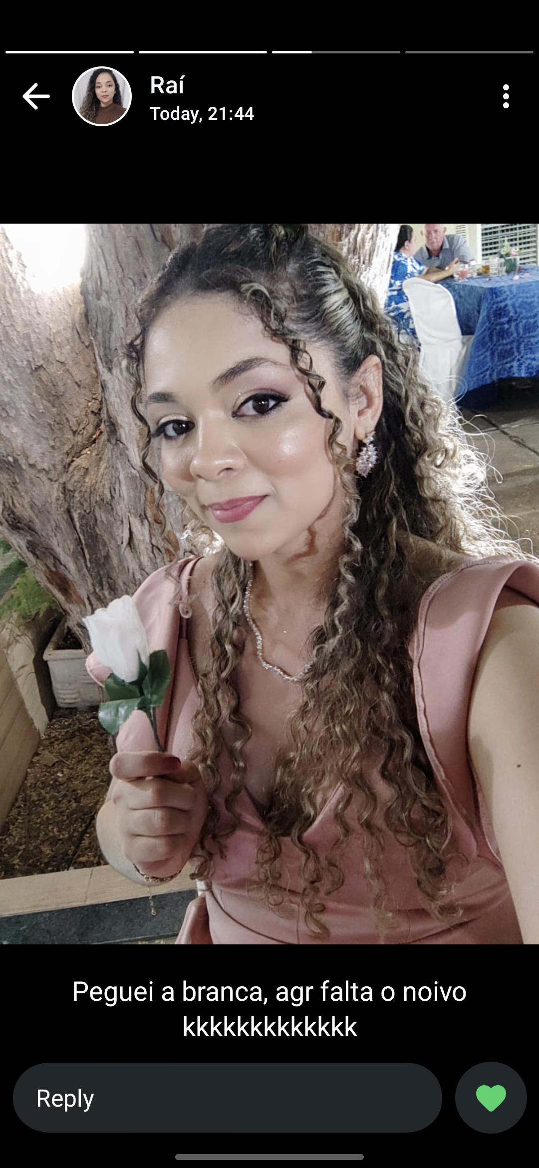 Raíla segurando uma rosa branca em um casamento